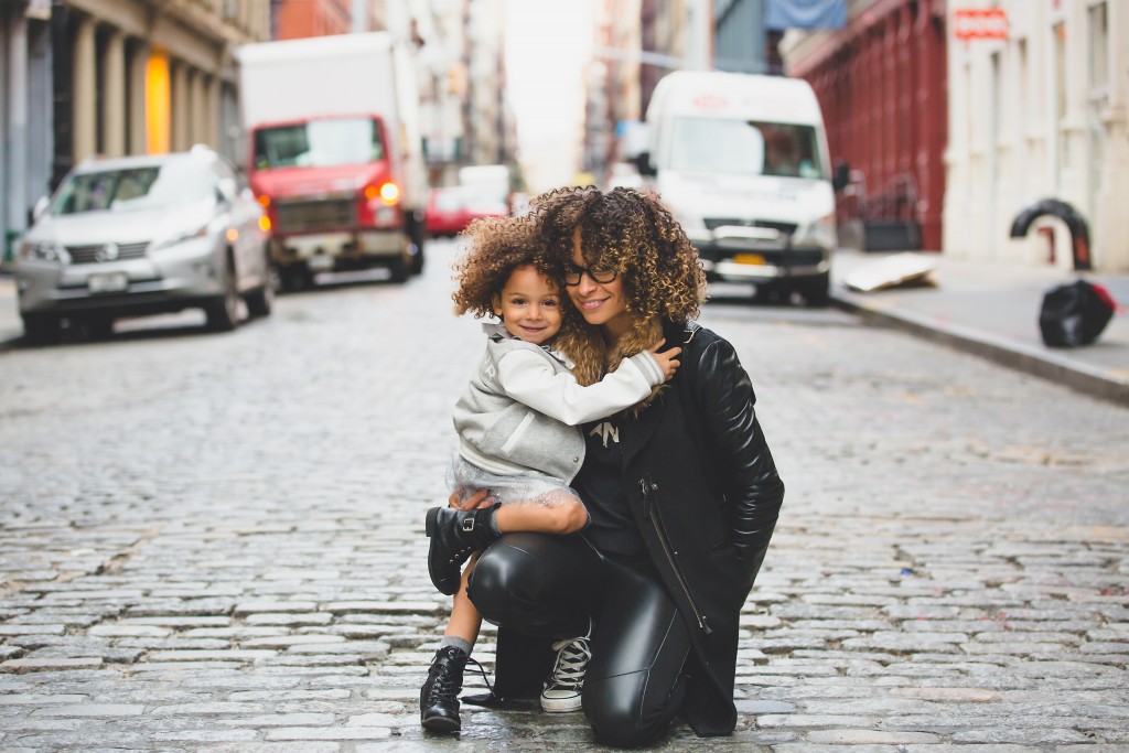 A Young Mother and daughter embrace ion a cobblestone street